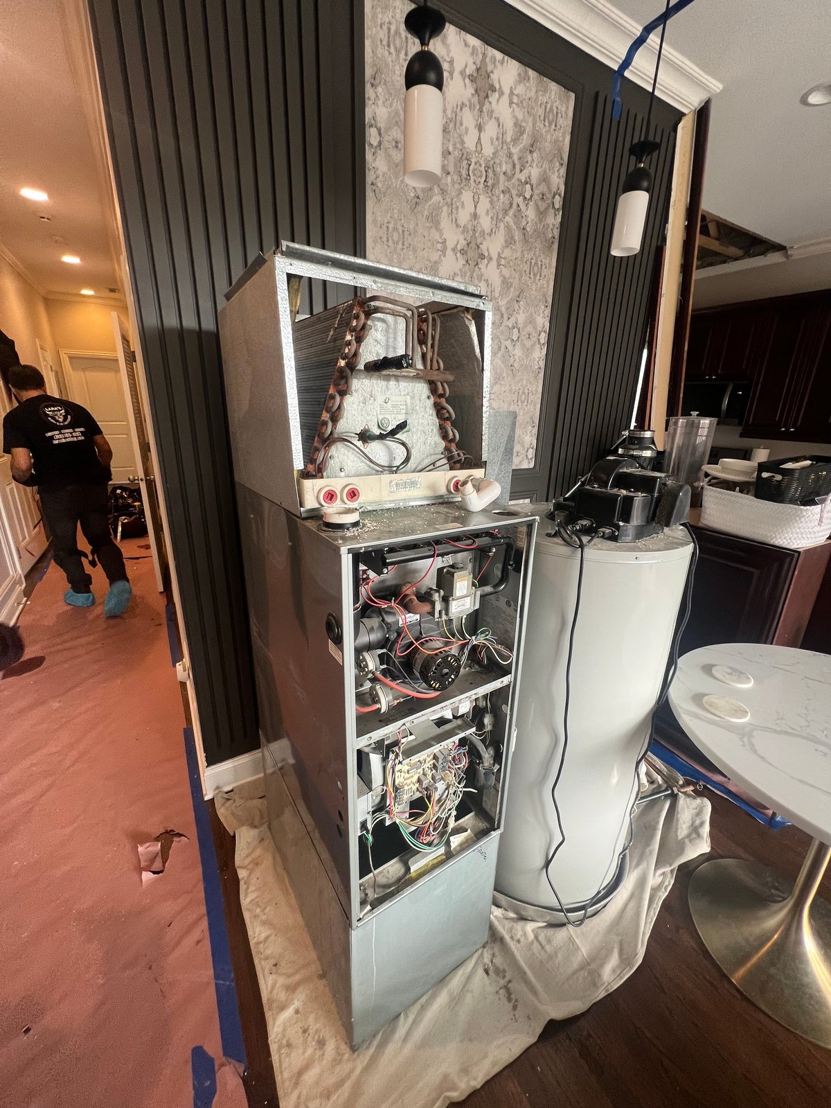 Open wall cabinet displaying internal mechanical and electrical components of an HVAC or appliance system in an indoor space