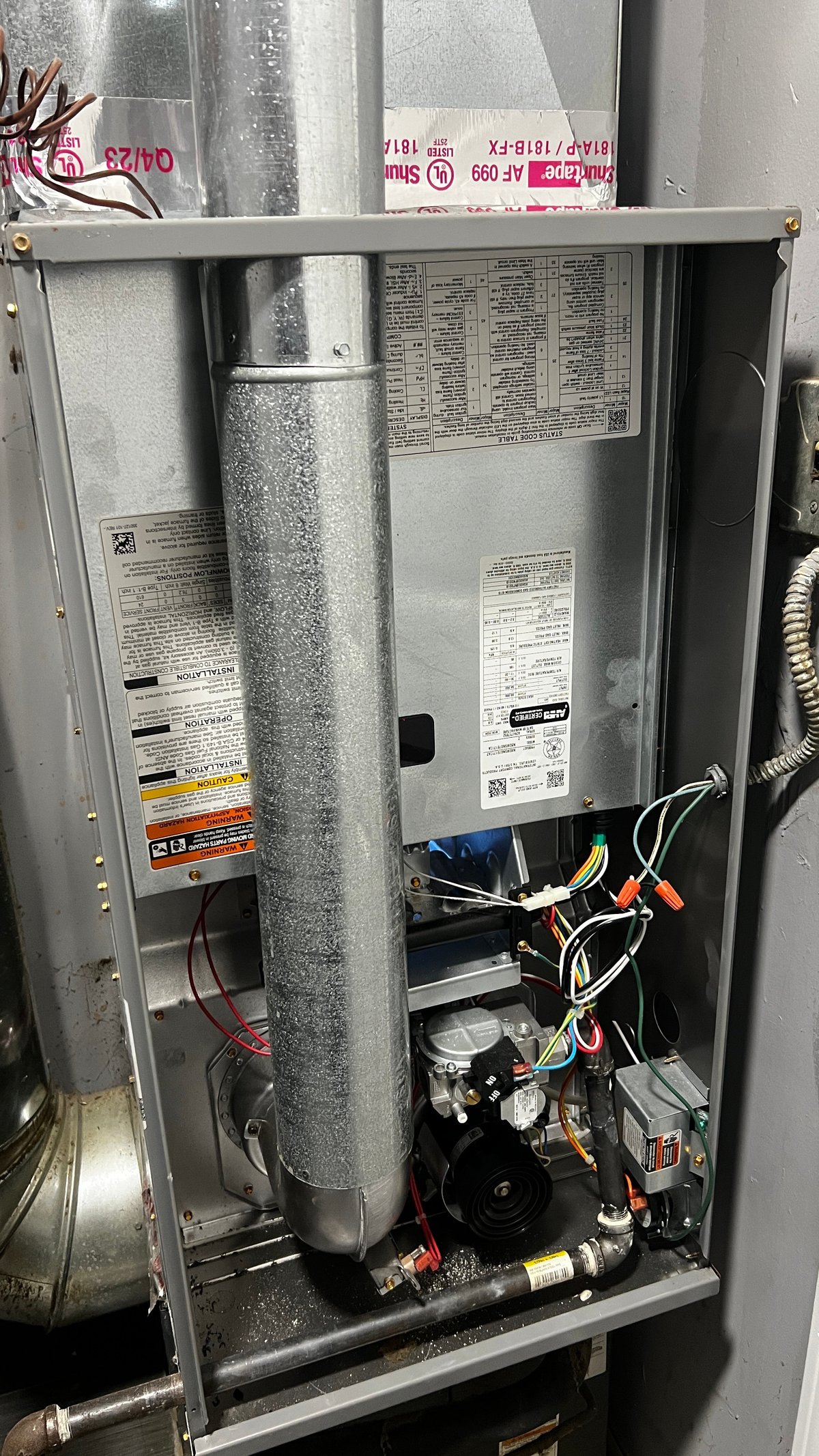 Interior view of an HVAC unit showing metal ductwork, compressor, wiring, and labeled components